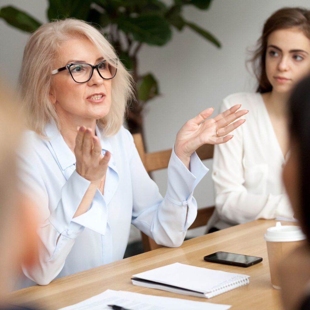 Picture of employees sitting at a table in an office setting.